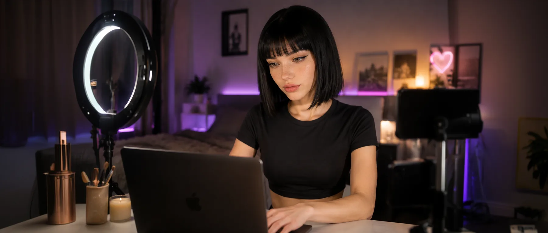 A creator working at her desk with a ring light, phone rig and laptop
